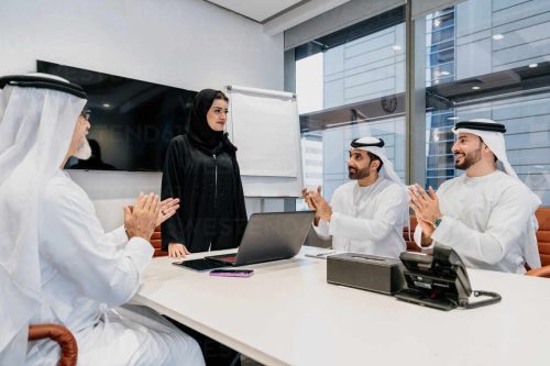 Group of middle-eastern corporate business people wearing traditional emirati clothes meeting in the office in Dubai - Business team working and brainstorming in the UAE